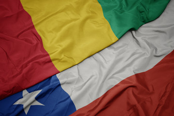 waving colorful flag of chile and national flag of guinea.