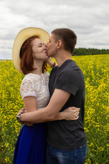 Beautiful couple kisses in a yellow rapeseed field