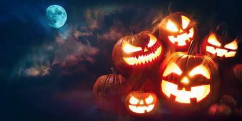 Halloween pumpkin head jack lantern with burning candles - obrazy, fototapety, plakaty