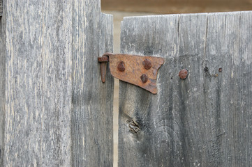 antique metal door hinge.  wooden window with old forged door hinge