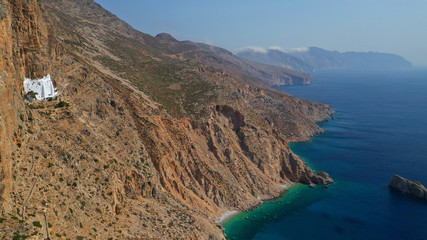 Aerial drone photo of breathtaking whitewashed holy Monastery of Panagia Hozoviotissa built in a steep cliff overlooking the Aegean deep blue sea, Amorgos island, Cyclades, Greece