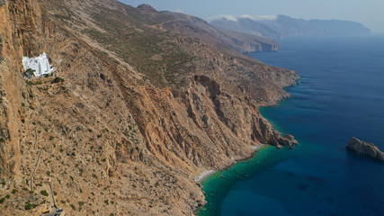 Aerial drone photo of breathtaking whitewashed holy Monastery of Panagia Hozoviotissa built in a steep cliff overlooking the Aegean deep blue sea, Amorgos island, Cyclades, Greece