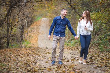 Fototapeta premium Young couple walking through the park. Autumn, fall romantic concept