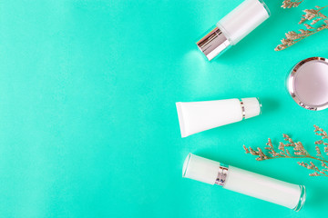Top view of white cosmetic bottle containers on color background.