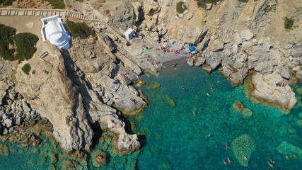 Aerial drone photo of iconic small chapel of Agia Anna built just above emerald rocky pebble beach,...