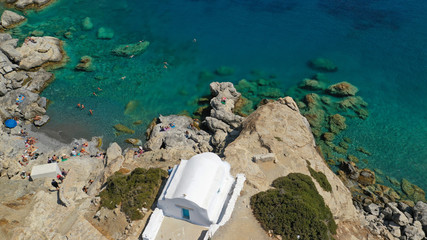 Aerial drone photo of iconic small chapel of Agia Anna built just above emerald rocky pebble beach,...