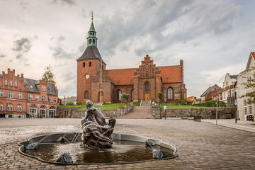 Vor Frue Kirke, Church  and fountain in the square of Svendborg against a grayish sky