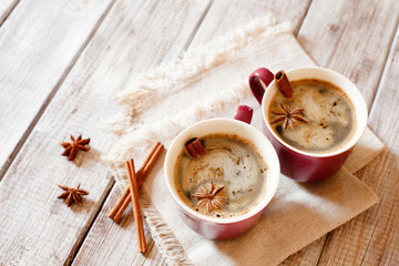 Two cups of  morning coffee with seasoning on white wooden table