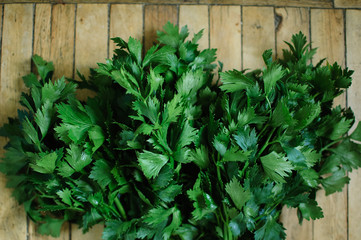 Bunch of fresh parsley celery on a wooden table. Healthy eating, raw food concept background. Fresh greens in the kitchen