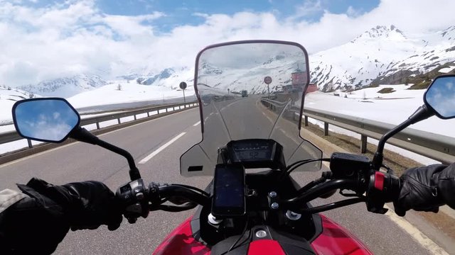 Motorcyclist Rides on Beautiful Landscape Snowy Mountain Road near Switzerland Alps