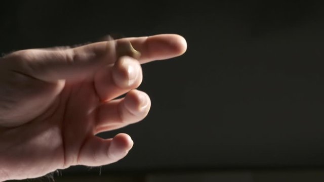 Hand tossing a coin. Throwing 1 Ukrainian hryvnia coin in the air close-up.