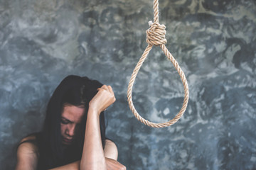 depressed Asian woman crying lonly with rope hanging  ,suicide concept 