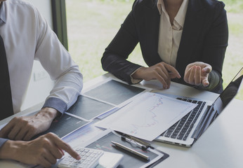 Businessmen are analyzing stock data, male company employees are discussing stock investment valuations, achieving business success.