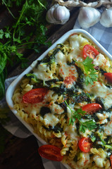Pasta casserole with spinach and cheese and cherry tomatoes