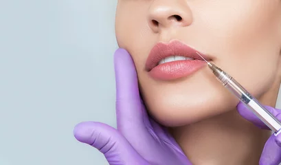 Fotobehang Cropped sensual female lips, procedure lip augmentation. Syringe near womans mouth, injections for increase lips shape © Peakstock