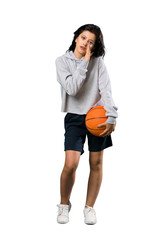 A full-length shot of a Young woman playing basketball whispering something over isolated white background