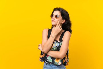 Young woman over isolated yellow background with glasses