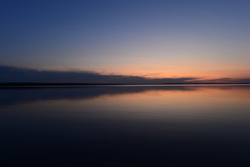 Obraz premium Blue sky in twilight over a mirrored calm surface of the lake