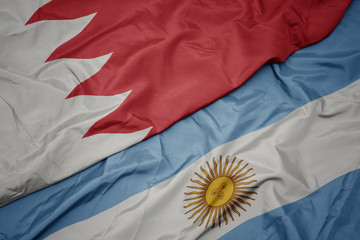 waving colorful flag of argentina and national flag of bahrain.