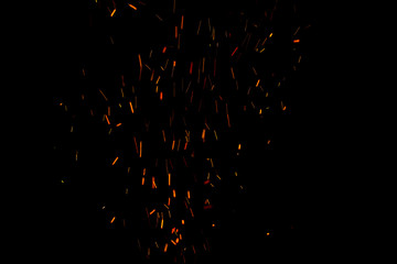 Burning red hot sparks fly from large fire in the night sky. Beautiful abstract background on the theme of fire, light and life. © Torkhov