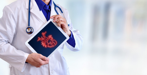 Doctor showing a heart on a tablet in hospital