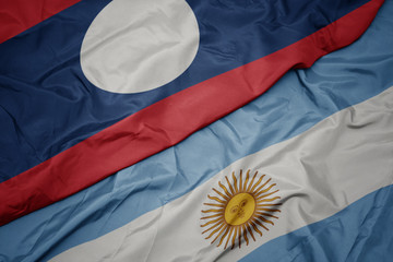 waving colorful flag of argentina and national flag of laos.