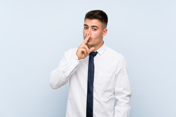 Handsome businessman over isolated blue background doing silence gesture