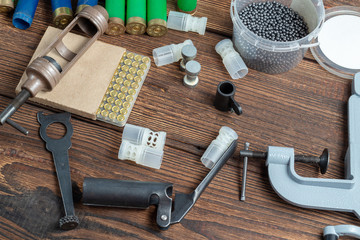 reloading process shotgun shells with special reload equipment. Powder, bullets, fraction, shells, buckshot on the wooden background