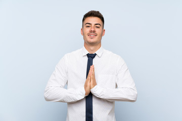 Handsome businessman over isolated blue background pleading