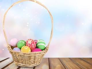 Easter basket filled with colorful eggs on a white background