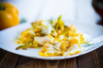 fried omelet from homemade eggs with sweet yellow pepper in a plate