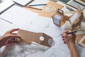 Designer sketching drawing design Brown craft cardboard paper product eco packaging mockup box development template package branding Label . designer studio concept . - obrazy, fototapety, plakaty