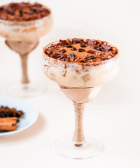 italian dessert tiramisu in an elegant cocktail glass, the concept of sweet life, luxury, delicious food