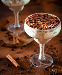 italian dessert tiramisu in an elegant cocktail glass, the concept of sweet life, luxury, delicious food