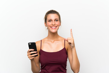 Naklejka premium Young blonde woman using mobile phone pointing with the index finger a great idea