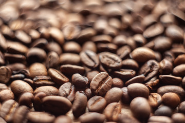 Roasted brown coffee beans, can be used as a background and texture. Coffee beans on the table background texture. Background full of coffe beans studio shoot.