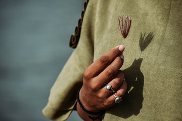 Girl hand holding flower and rings in fingers.