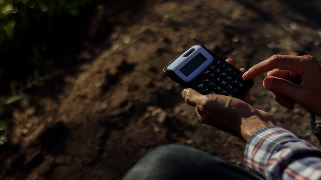 Calculator in the hands of a man on natural morning. - Powered by Adobe