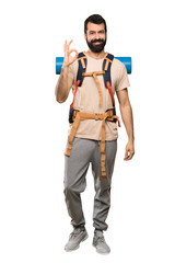 Hiker man showing ok sign with fingers over isolated white background