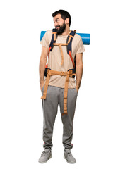 Hiker man making doubts gesture looking side over isolated white background