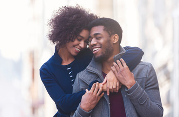 Portrait of young african couple embracing on the street