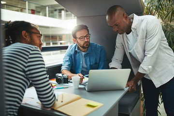 Designers working on a laptop in an office meeting pod
