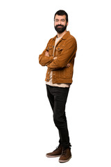 Handsome man with beard with arms crossed and looking forward over isolated white background