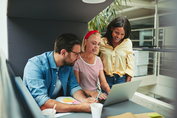 Smiling businesspeople working together in an office meeting pod