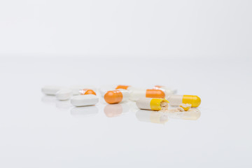 white and orange medicin pills on white table