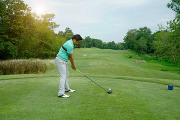 Blurred golfer playing golf in beautiful golf course in the evening golf course with sunshine in thailand