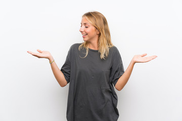 Fototapeta premium Blonde young woman over isolated white background holding copyspace with two hands