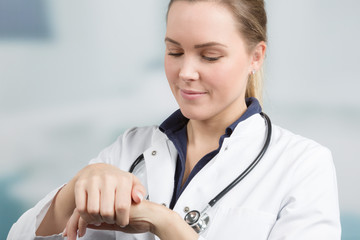 young female doctor is applying protective hand cream