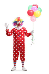 Smiling clown holding a bunch of balloons and waving