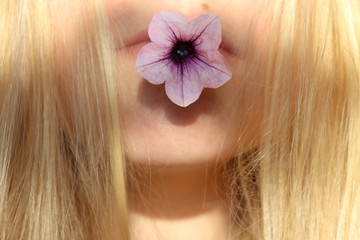 Obraz na płótnie Canvas blondes Mädchen mit Blume im Mund